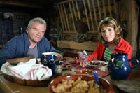 Image montrant Heidi (jouée par Ellodie Bollée) et son grand-père (joué par Christian Sinniger) prenant le petit-déjeuner au chalet